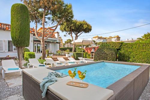 una piscina con 2 copas de vino en una mesa en Villa Erika Beach House, en Malgrat de Mar