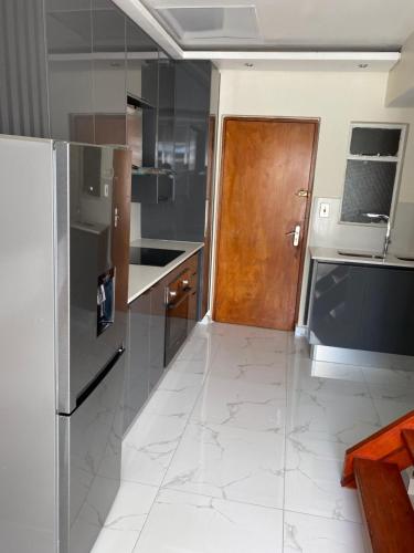 a kitchen with stainless steel appliances and a wooden door at Unit 76 Melville Mews in Johannesburg