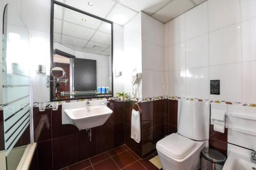 a bathroom with a sink and a toilet and a mirror at Portaluna Hotel & Resort in Jounieh