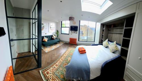 a bedroom with a large bed and a living room at Boutique Linden Gardens 1st floor and loft apartments in London
