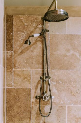 une douche avec pommeau de douche dans une salle de bain dans l'établissement Maison Guy, à Saint-Bauzély