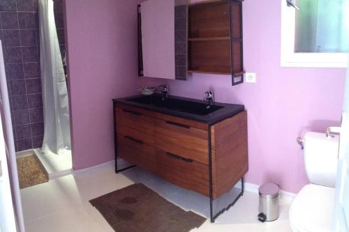 La salle de bains est pourvue d'un lavabo, de toilettes et de murs violets. dans l'établissement Villa avec piscine privée dans un havre de paix, à Peri