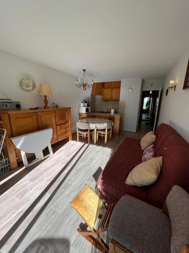 a living room with a couch and a kitchen at Les Sources appartement T2 in Enchastrayes