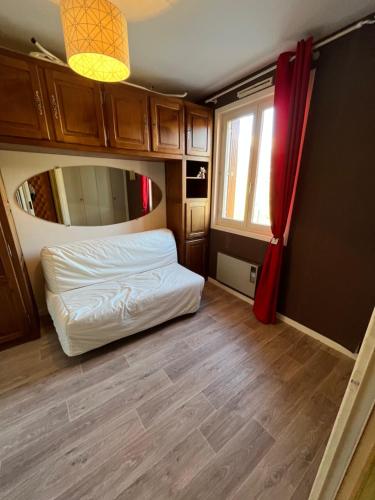 um pequeno quarto com uma cama e um espelho em Les Sources appartement T2 em Enchastrayes