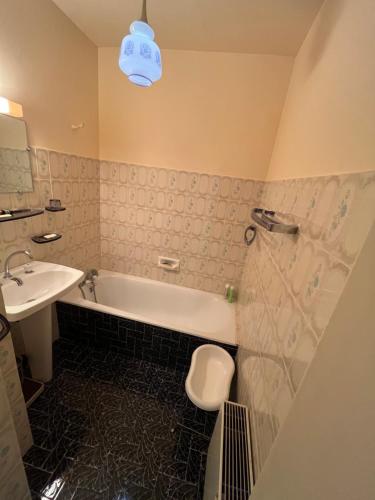 a bathroom with a tub and a toilet and a sink at Les Sources appartement T2 in Enchastrayes