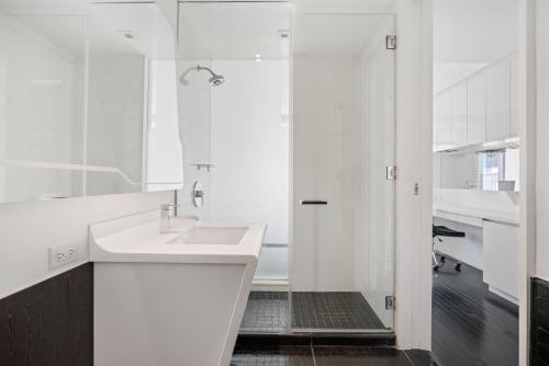 a white bathroom with a sink and a shower at Financial District w WD gym elevator NYC-1366 in New York