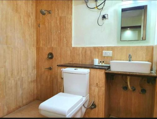 a bathroom with a white toilet and a sink at Hotel Logix in Noida