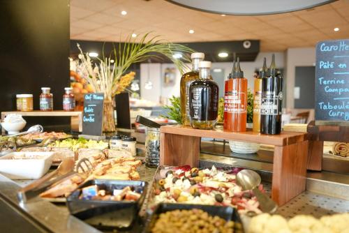 a buffet with many different types of food on a counter at Campanile Paris CDG Airport Villepinte in Roissy-en-France