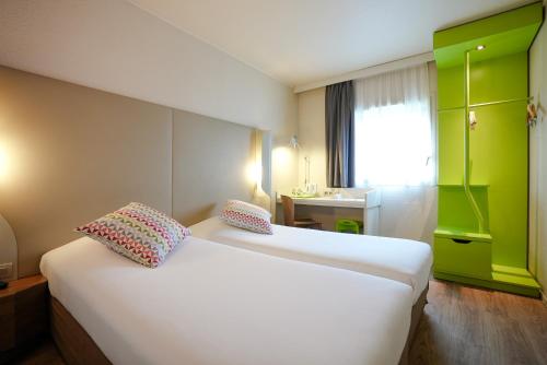 a hotel room with two beds and a sink at Campanile Paris CDG Airport Villepinte in Roissy-en-France