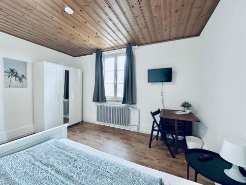 a bedroom with a bed and a desk and a television at Monteurzimmer ZIMMERzuVERMIETEN in Biberist in Biberist