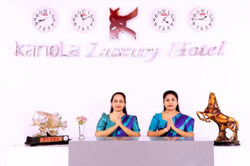 two women are sitting at a table with clocks at Kanola Luxury Hotel in Anuradhapura