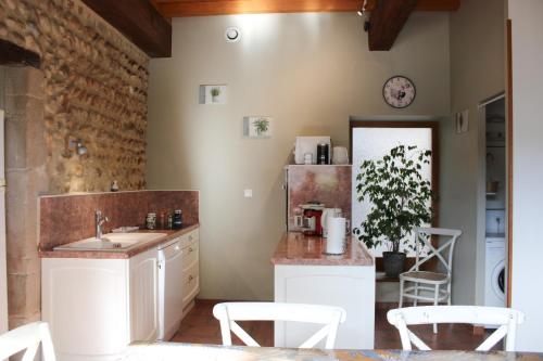 a kitchen with a sink and a counter with chairs at Les Gîtes de Genas in Bourg-lès-Valence