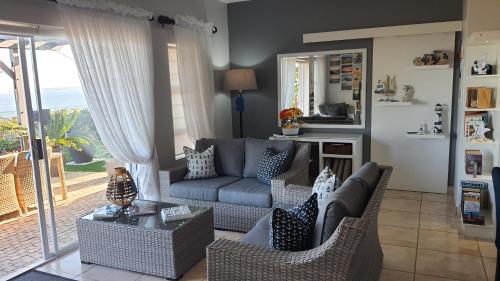 a living room with a couch and a table at Amelia's by the Sea in Groot Brak Rivier