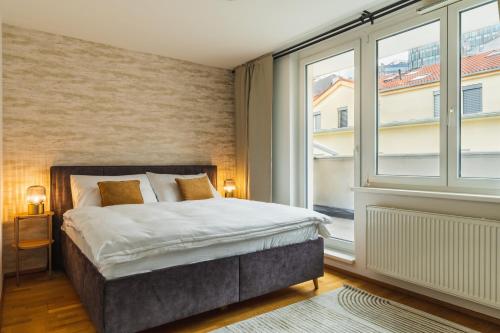 a bedroom with a bed and a large window at Business & Family Ambiente Apartments in Bratislava