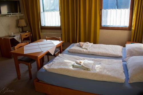 a hotel room with two beds and a table at Hotel-Restaurant Denklinger-Hof in Reichshof 