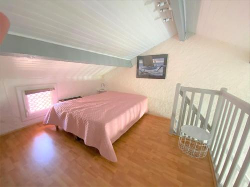 - une chambre avec un lit rose et un escalier dans l'établissement studio mezzanine climatisé 40 M2 bord de mer, à Lecci