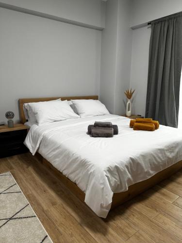 a large white bed with two towels on it at JP Luxury Apartment in citycenter in Xanthi