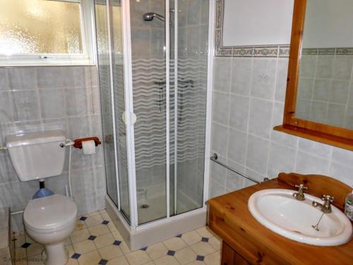 a bathroom with a shower and a toilet and a sink at 14 Links Way in West Runton