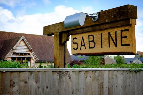 a wooden sign that reads saine next to a fence at Sabine Barn B&B in Oxford