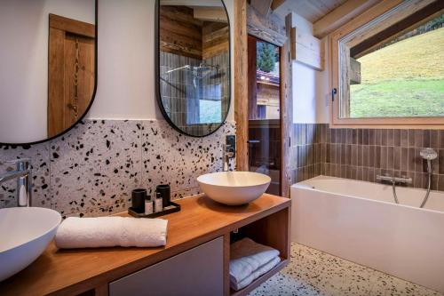 La salle de bains est pourvue d'un lavabo et d'une baignoire. dans l'établissement Chalet Fernand - OVO Network, à La Clusaz