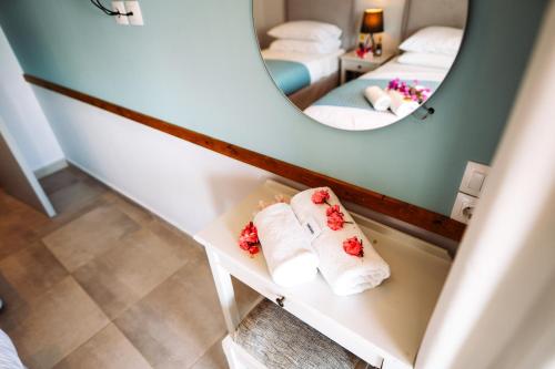 een badkamer met handdoeken op een plank voor een spiegel bij The Flower Garden in Ýpsos
