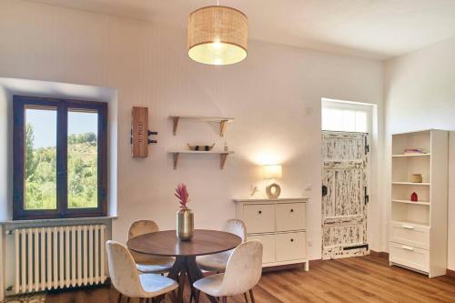 ein Esszimmer mit einem Tisch, Stühlen und einem Fenster in der Unterkunft Il Leccio Country House in Siena