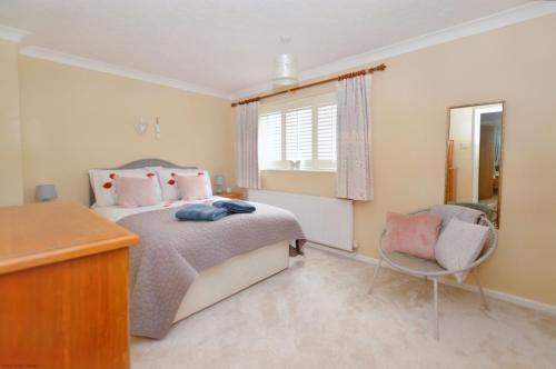 a bedroom with a bed and a desk and a chair at 18 Marriotts Way in Sheringham