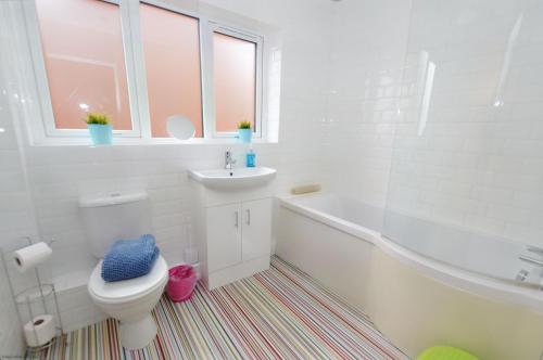 La salle de bains blanche est pourvue de toilettes et d'un lavabo. dans l'établissement 18 Marriotts Way, à Sheringham
