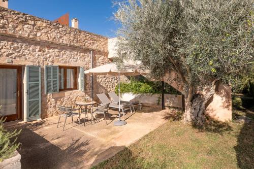 a patio with a table and chairs and an umbrella at Hotel Sa Franquesa Nova in Vilafranca de Bonany