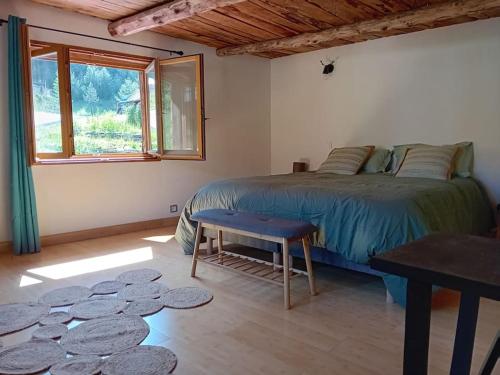 une chambre avec un lit, une table et une fenêtre dans l'établissement Appartement chalet hameau de Souliers - Queyras, à Château-Ville-Vieille