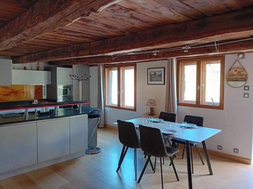 une cuisine et une salle à manger avec une table et des chaises dans l'établissement Appartement chalet hameau de Souliers - Queyras, à Château-Ville-Vieille
