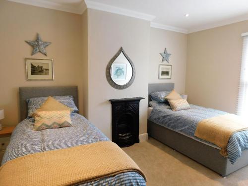 une chambre avec deux lits et un miroir dans l'établissement Paddlestop House, à Sheringham
