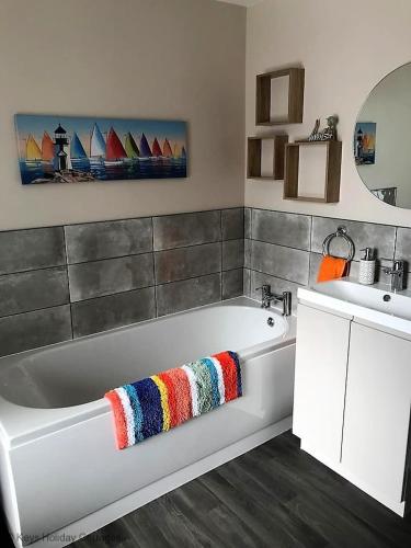 a bathroom with a white tub and a sink at Paddlestop House in Sheringham