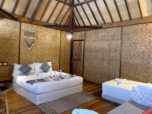 Cette chambre comprend 2 lits et une table. dans l'établissement Villa Bagheera, à Gili Trawangan