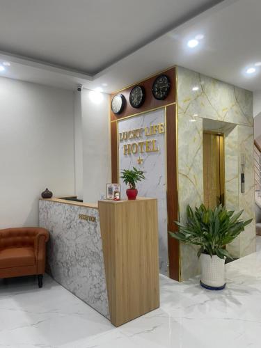 a hotel lobby with a reception desk and clocks on the wall at lucky life hotel in Ấp Nhât (2)