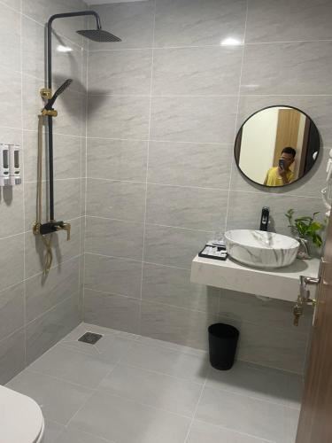 a man taking a picture of a bathroom with a sink at lucky life hotel in Ấp Nhât (2)
