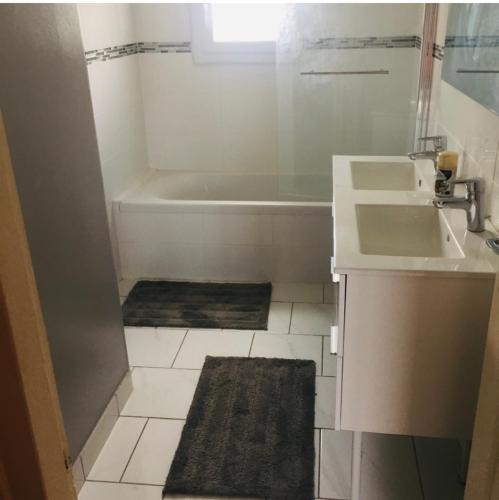 La petite salle de bains est pourvue d'un lavabo et d'une baignoire. dans l'établissement Maison à proximité du Futuroscope, à Buxerolles