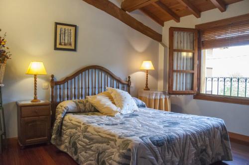 1 dormitorio con 1 cama con 2 lámparas y una ventana en Casa Rural Edulis en Santurde