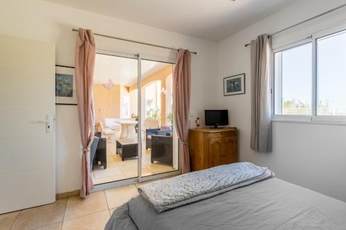 une chambre avec un lit et une porte coulissante en verre dans l'établissement Villa Entre Mer Et Montagnes, à Montesquieu