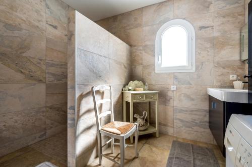 La salle de bains est pourvue d'une chaise et d'un lavabo. dans l'établissement Villa Entre Mer Et Montagnes, à Montesquieu
