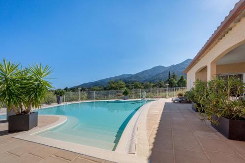 - une piscine dans un bâtiment avec des montagnes en arrière-plan dans l'établissement Villa Entre Mer Et Montagnes, à Montesquieu