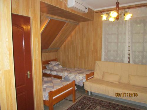 a bedroom with two beds and a couch in it at Kisherceg Szálláshely in Budapest