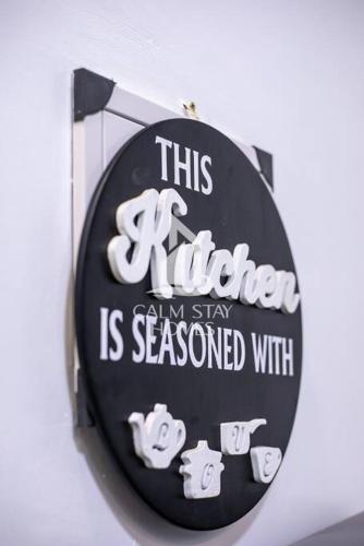 a sign that says this kitchen im stay is seasoned with at The Gray Haven Lakeside Condo in Entebbe in Entebbe