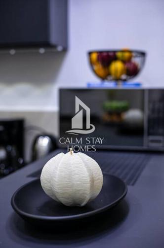a white pumpkin sitting on a black plate on a counter at The Gray Haven Lakeside Condo in Entebbe in Entebbe