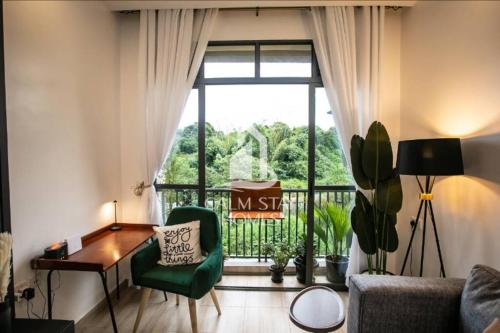 a living room with a green chair and a window at The Gray Haven Lakeside Condo in Entebbe in Entebbe