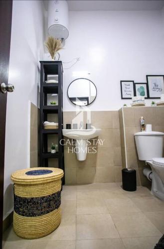 a bathroom with a sink and a toilet and a stool at The Gray Haven Lakeside Condo in Entebbe in Entebbe