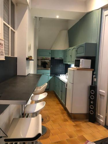 eine Küche mit grünen Schränken und weißen Geräten in der Unterkunft Hyper Centre LILLE appt. 6 personnes confortable pour famille ou amis in Lille