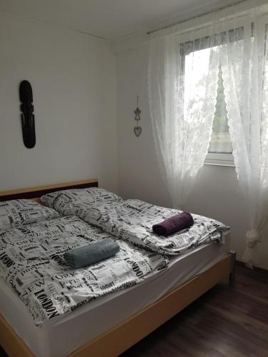 una camera da letto con un letto con cuscini e una finestra di Csillagmajor a Csabrendek