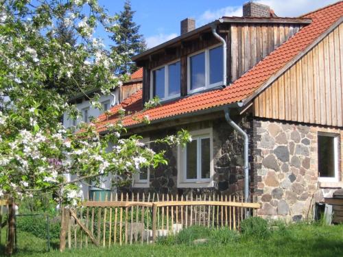 a stone house with a red roof at Ferienwohnung Bergschäferei in Liebenhof