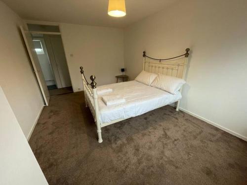 a bedroom with a white bed in a room at Large 2 bedroom house in Wombridge
